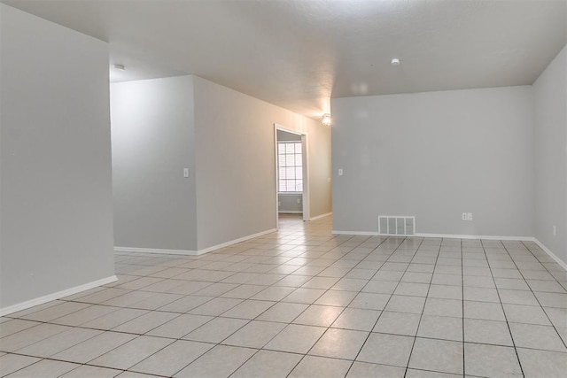 spare room with light tile patterned floors, baseboards, and visible vents