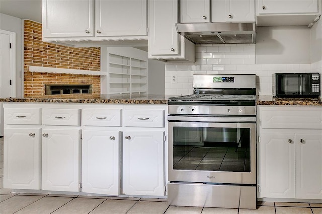 kitchen featuring black microwave, range hood, stainless steel gas range oven, and light tile patterned flooring