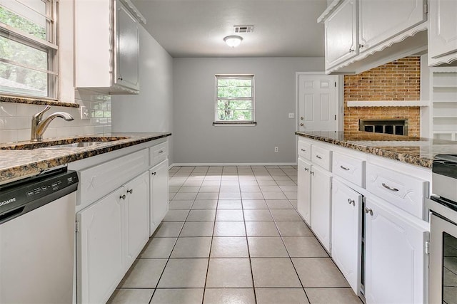kitchen featuring stainless steel dishwasher, white cabinets, and visible vents