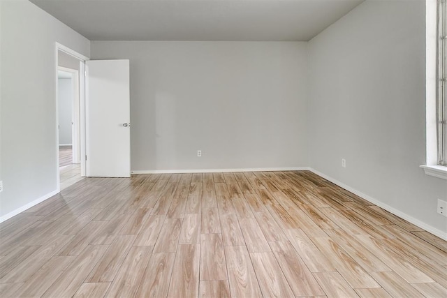 empty room with baseboards and light wood finished floors