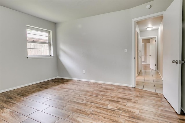 unfurnished room featuring baseboards and light wood-type flooring