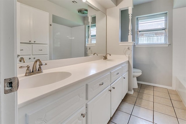 bathroom with double vanity, a sink, tile patterned flooring, and toilet