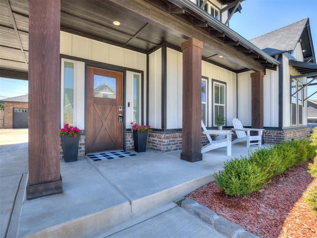 doorway to property with a garage and covered porch