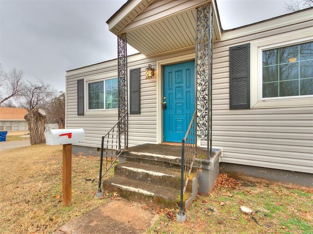 view of exterior entry featuring a yard