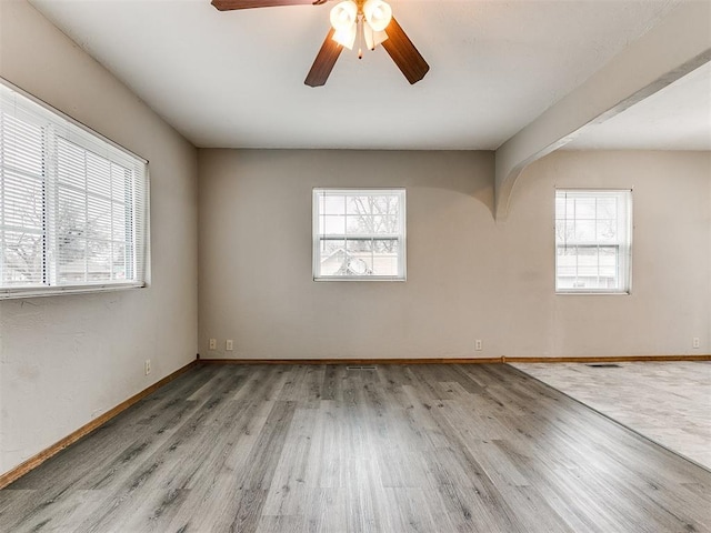 unfurnished room with ceiling fan, light hardwood / wood-style floors, and a healthy amount of sunlight