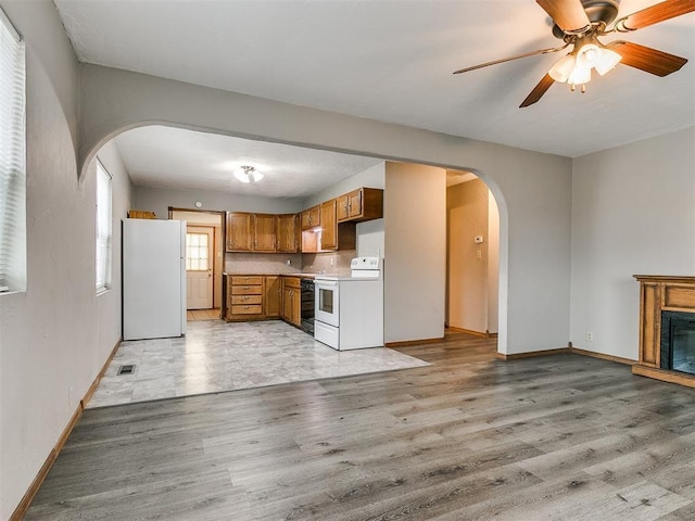 kitchen featuring ceiling fan, white appliances, tasteful backsplash, and light wood-type flooring