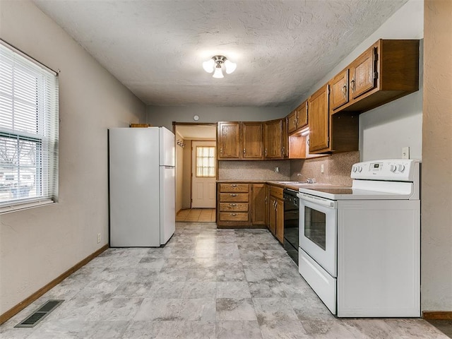 kitchen with white appliances, decorative backsplash, and a textured ceiling