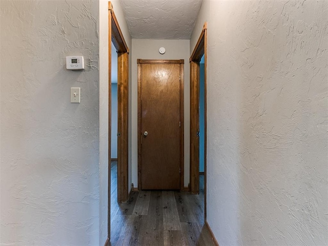 corridor featuring hardwood / wood-style floors and a textured ceiling