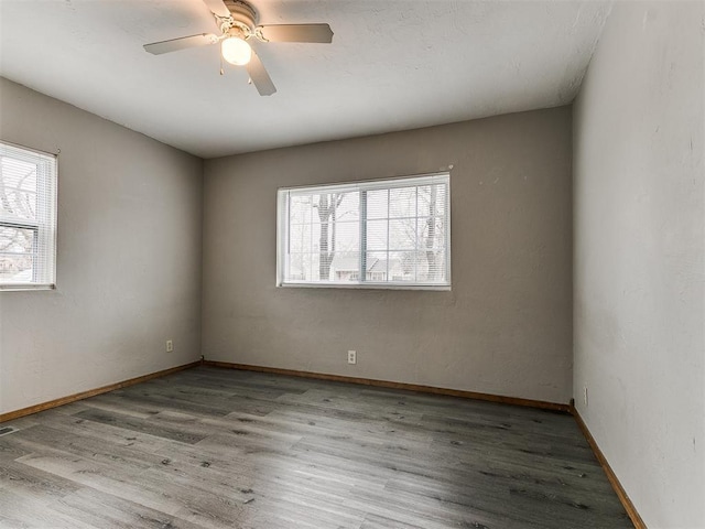 empty room featuring ceiling fan, plenty of natural light, and light wood-type flooring