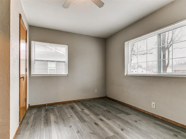 empty room with ceiling fan and light wood-type flooring