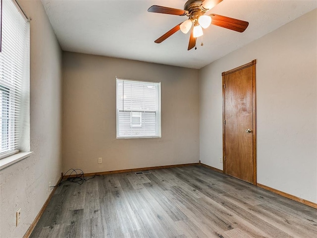 spare room featuring ceiling fan, light hardwood / wood-style flooring, and a wealth of natural light