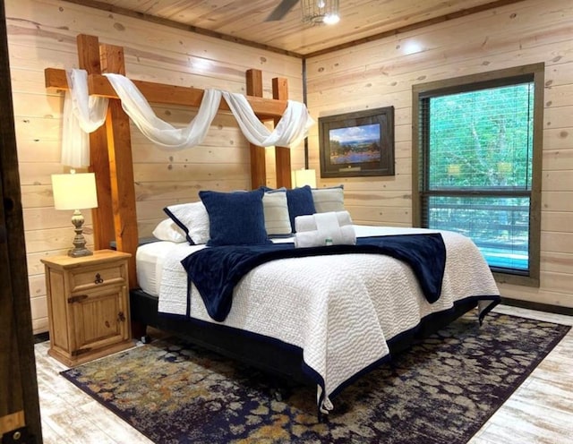 bedroom with wooden ceiling, wooden walls, and light hardwood / wood-style flooring