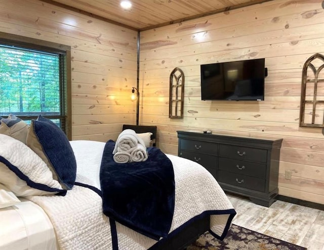 bedroom with wood walls, light hardwood / wood-style flooring, and wooden ceiling