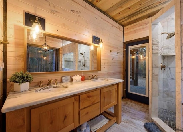 bathroom with a tile shower, wood walls, hardwood / wood-style flooring, vanity, and wooden ceiling