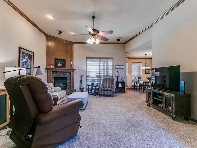 living room featuring crown molding, carpet, ceiling fan with notable chandelier, and a high end fireplace