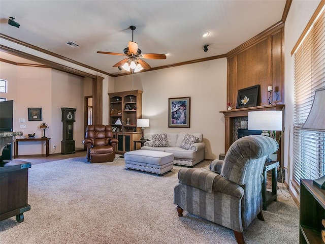 living room with carpet floors, ornamental molding, a large fireplace, and ceiling fan