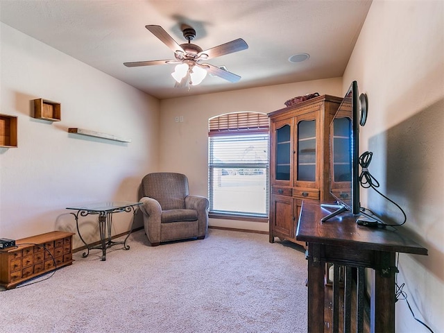 living area featuring carpet flooring and ceiling fan