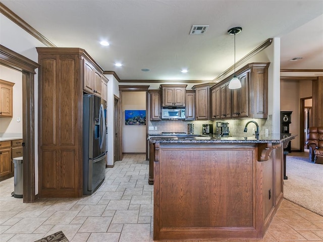 kitchen featuring appliances with stainless steel finishes, dark stone countertops, backsplash, and kitchen peninsula