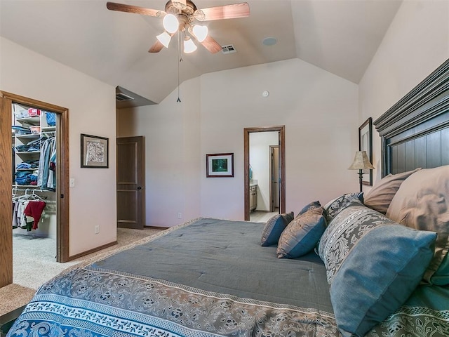 carpeted bedroom with connected bathroom, a walk in closet, vaulted ceiling, a closet, and ceiling fan