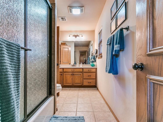 full bathroom featuring vanity, toilet, tile patterned flooring, and combined bath / shower with glass door