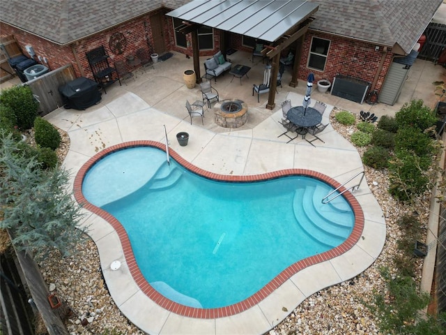 view of swimming pool with area for grilling, a patio area, and an outdoor fire pit