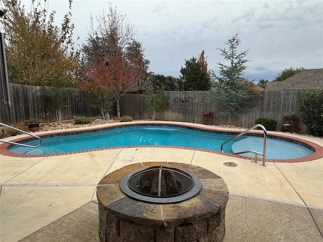 view of pool with a fire pit and a patio area