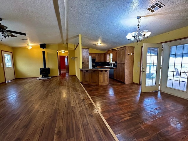 kitchen featuring lofted ceiling, visible vents, open floor plan, and dark wood-style flooring