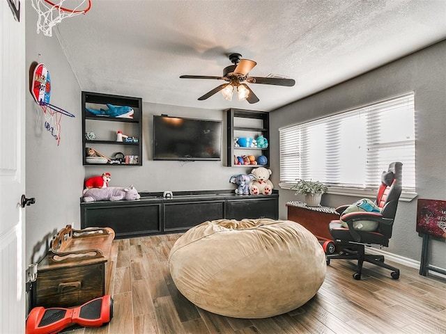 interior space featuring ceiling fan, hardwood / wood-style floors, and a textured ceiling