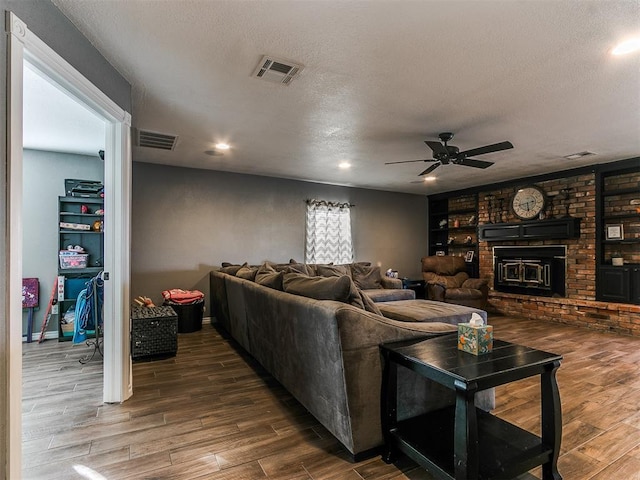 living room with ceiling fan, dark hardwood / wood-style floors, and a textured ceiling