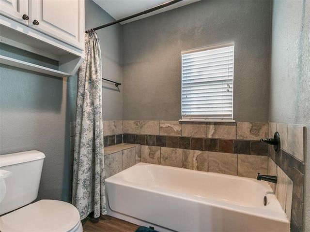 bathroom featuring wood-type flooring, toilet, and a bathtub