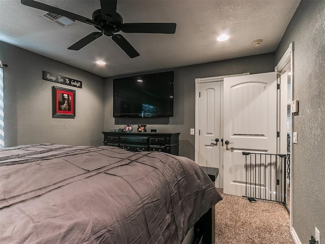 carpeted bedroom featuring ceiling fan, a closet, and a textured ceiling