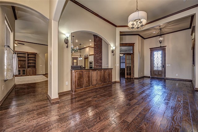 foyer featuring ornamental molding, dark hardwood / wood-style floors, and a chandelier