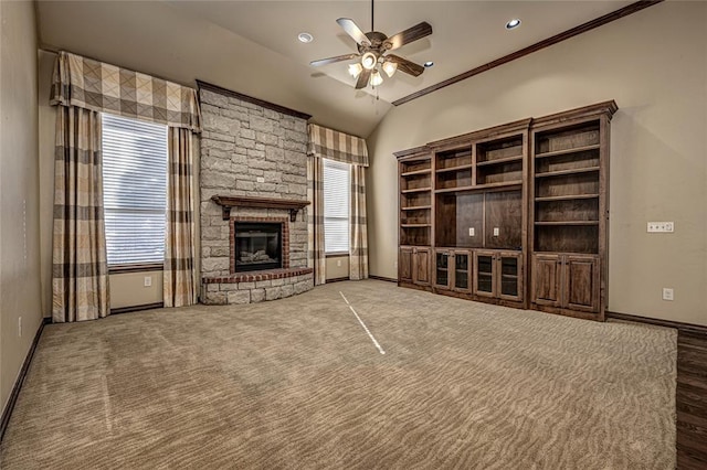 unfurnished living room featuring vaulted ceiling, a wealth of natural light, ceiling fan, and a fireplace