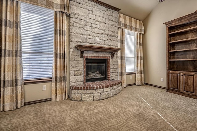 unfurnished living room with lofted ceiling, a fireplace, and light carpet