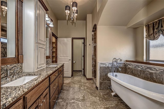 bathroom featuring vanity, a bathtub, and a chandelier