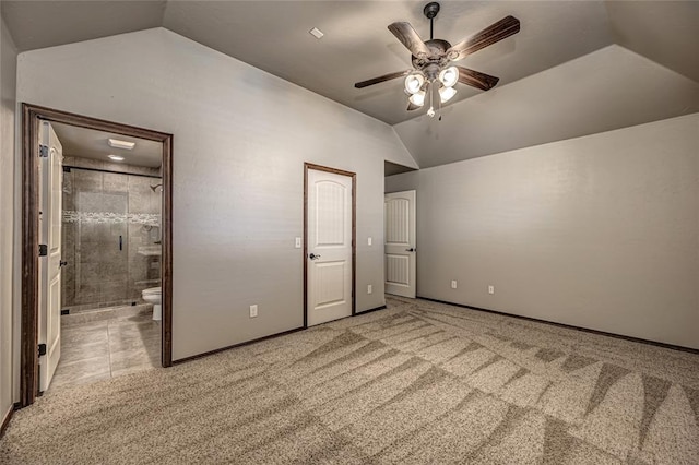 unfurnished bedroom with vaulted ceiling, ceiling fan, connected bathroom, and carpet floors