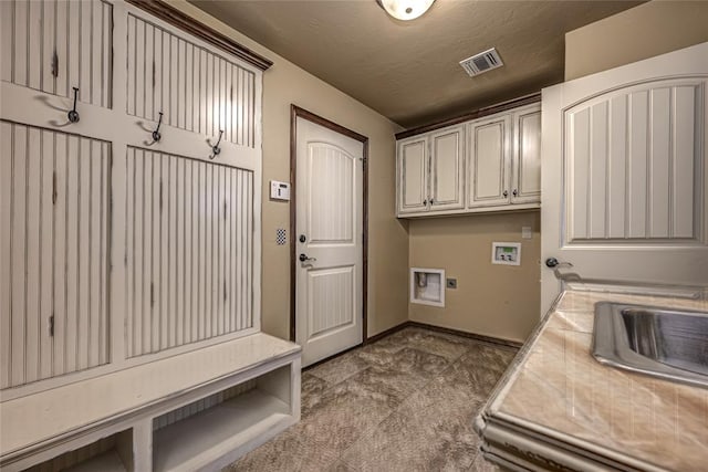 clothes washing area with cabinets, sink, hookup for a washing machine, and a textured ceiling