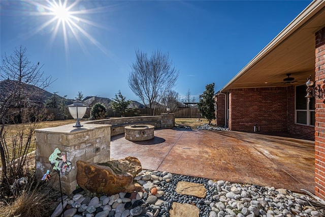 view of patio / terrace with ceiling fan, a mountain view, and a fire pit