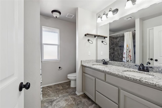 bathroom with walk in shower, vanity, and toilet