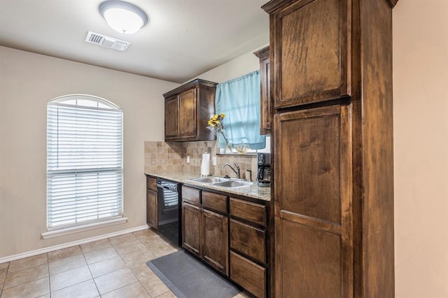 kitchen with light tile patterned floors, a sink, visible vents, black dishwasher, and tasteful backsplash