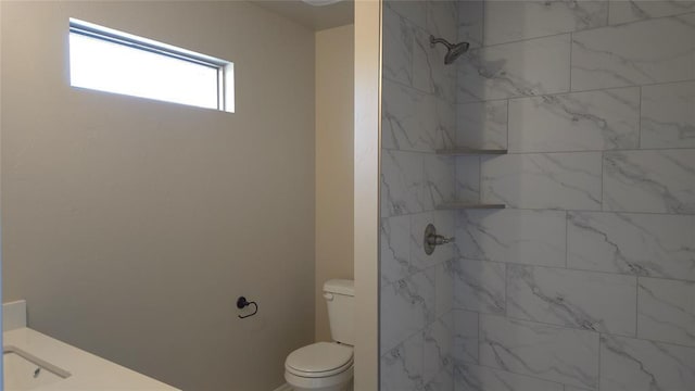 bathroom with tiled shower and toilet