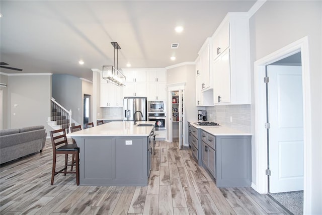 kitchen featuring white cabinetry, gray cabinets, and stainless steel appliances