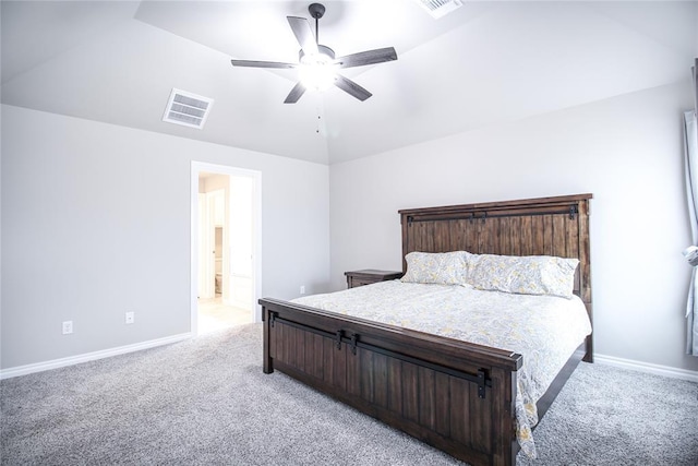 carpeted bedroom with ceiling fan, lofted ceiling, and ensuite bath