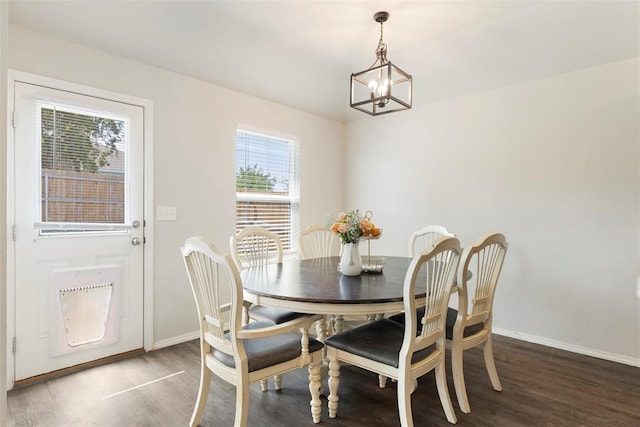 dining room with dark hardwood / wood-style floors and a chandelier