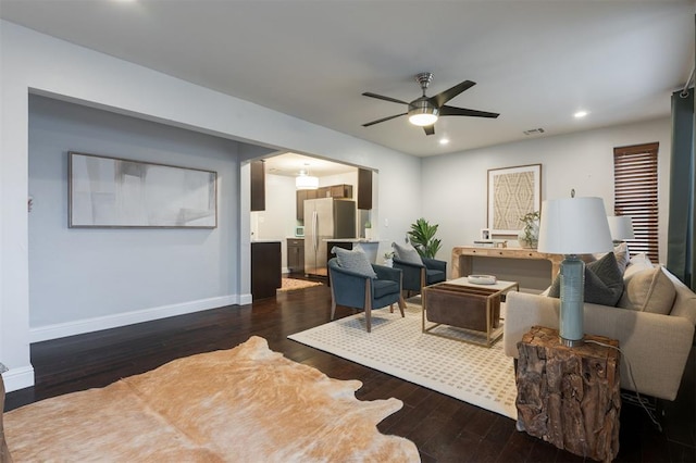 living room with dark wood-type flooring and ceiling fan