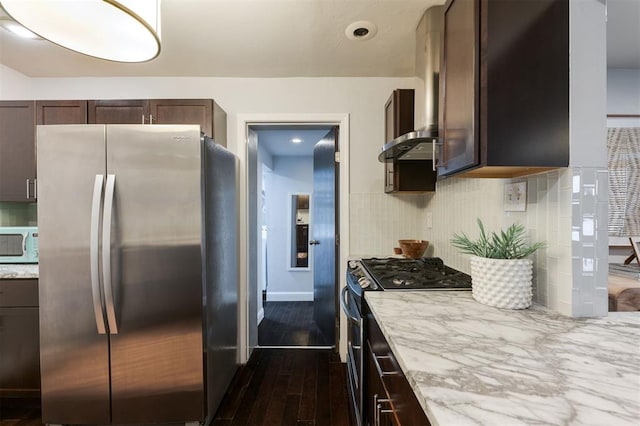 kitchen featuring tasteful backsplash, light stone counters, dark brown cabinets, dark hardwood / wood-style flooring, and stainless steel appliances