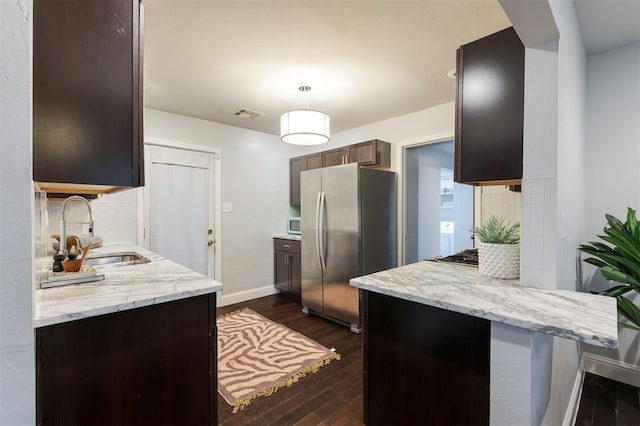 kitchen featuring pendant lighting, sink, dark wood-type flooring, appliances with stainless steel finishes, and tasteful backsplash