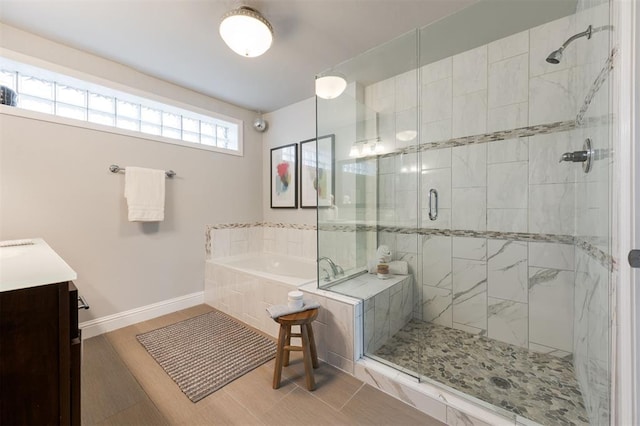 bathroom with vanity and shower with separate bathtub