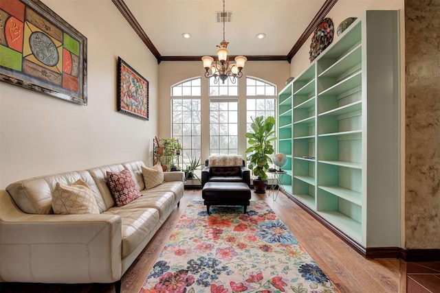 living room featuring ornamental molding, a chandelier, and hardwood / wood-style floors