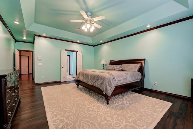 bedroom with dark wood-type flooring, crown molding, and a raised ceiling